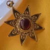 Gold Tone Brass Sun Star Pendant with Maroon Cabochon